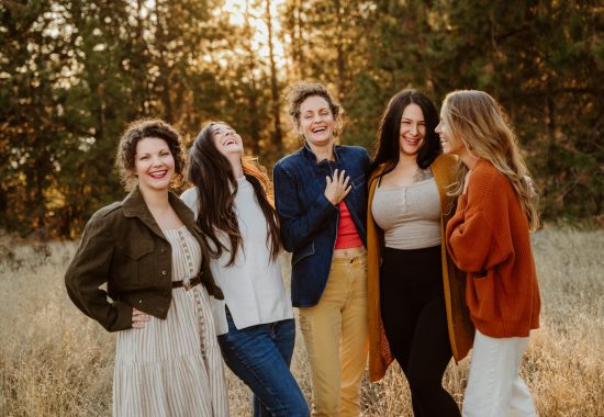 A group of women standing next to each other in a field